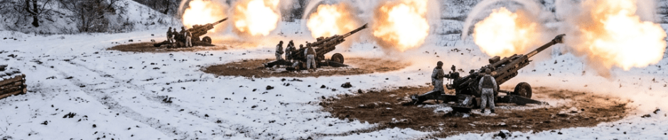 Artillery cannons firing with soldiers in snowy landscape