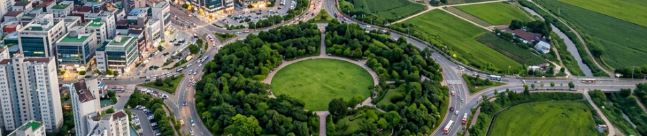 Aerial view of high-rise apartments, roundabout, roads, and farmland