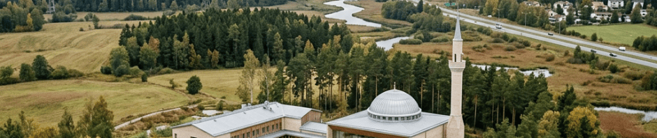 A modern mosque with dome and minaret surrounded by forests and wetlands